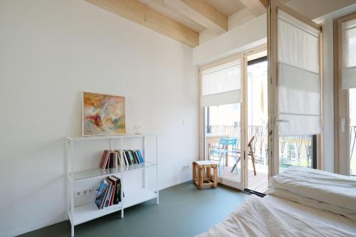 a bedroom with a bed and a large window at SCHICK und LUFTIG im Herzen von Linz in Linz