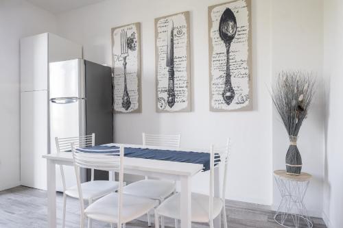 ボローニャにあるBologna Accommodation - Fiera - Self checkin - 24hのキッチン(白いテーブル、椅子、冷蔵庫付)