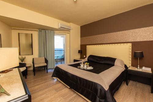a bedroom with a large bed and a large window at Mati Hotel in Mati