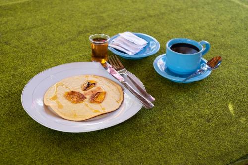 a plate with a pancake and a cup of coffee at Maringo cottage in Gili Trawangan