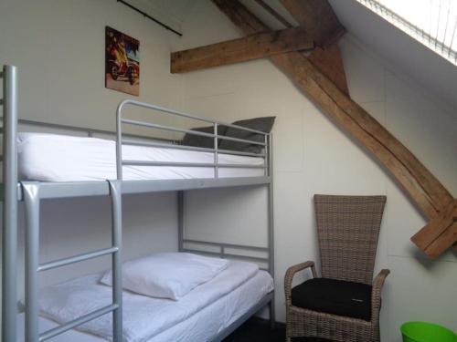 um beliche num quarto com uma cadeira em appartement met 5 slaapkamers em Moerstraten