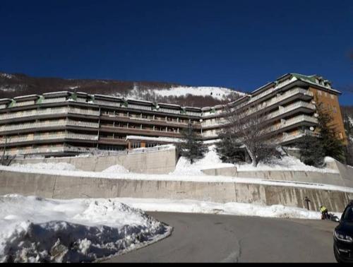 ein großes Gebäude mit Schnee davor in der Unterkunft Faggio Rosso in Filettino