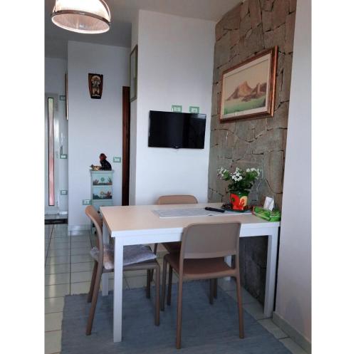 a dining room with a white table and chairs at Fronte mare in Castelsardo