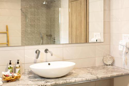 a bathroom with a white sink and a mirror at WHITE DONKEY BOUTIQUE Hotel in Chrani
