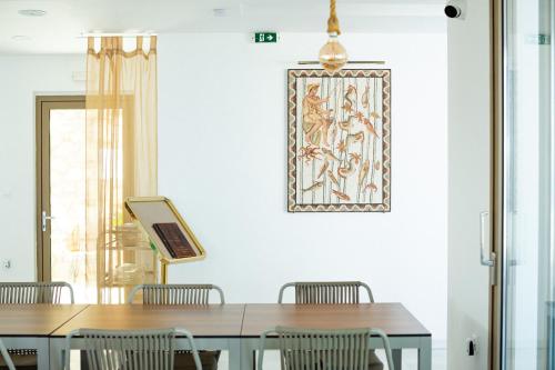 a dining room with tables and chairs and a picture on the wall at WHITE DONKEY BOUTIQUE Hotel in Chrani