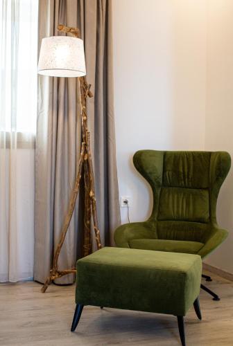 a green chair and a lamp in a room at WHITE DONKEY BOUTIQUE Hotel in Chrani