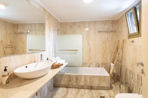 a bathroom with a large white tub and a sink at WHITE DONKEY BOUTIQUE Hotel in Chrani