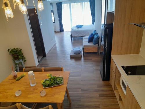 a living room with a dining table and a kitchen at Happy Home in Nha Trang