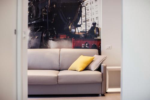 a couch in a living room with a yellow pillow at Love Boat Hotel - The Original in Riccione