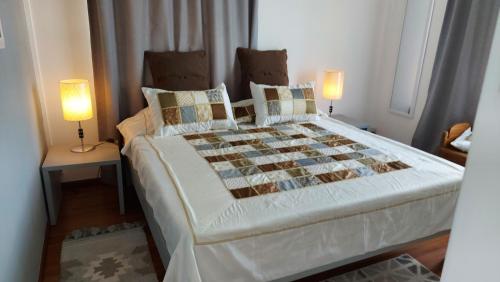 1 dormitorio con 1 cama grande y 2 lámparas en Tropical Palms apartment Mauritius en Pointe aux Cannoniers