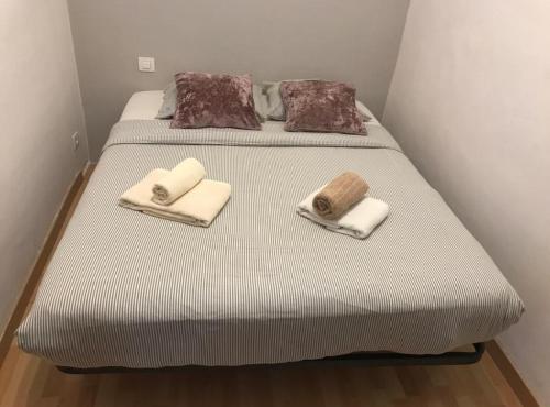 uma cama com toalhas e almofadas em cima em Rustic 2 bedroom apartment Poble Sec em Barcelona