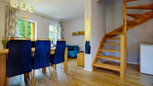a dining room with a table and blue chairs at U Gruszków - domek pod Chojnikiem in Jelenia Góra