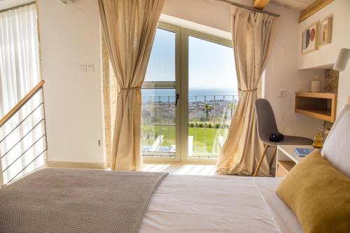 a bedroom with a bed and a large window at ArtHill eco villas in Nikiti
