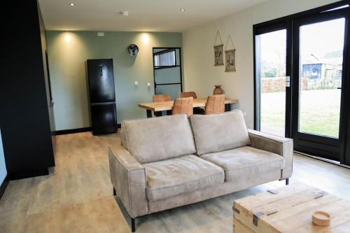 a living room with a couch and a table at Vakantiewoning 'De Eijk' in Doornspijk