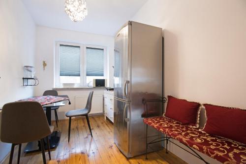 a room with a refrigerator and a table with a chair at Apartament na Fatimskiej in Kraków