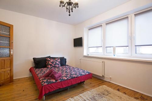 a bedroom with a bed in a room with windows at Apartament na Fatimskiej in Kraków