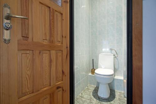 a bathroom with a toilet next to a door at Apartament na Fatimskiej in Kraków