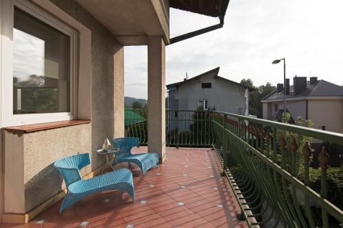 two blue chairs on a balcony with a window at Apartament na Fatimskiej in Kraków