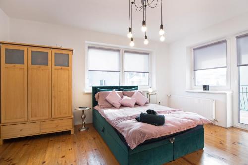 a bedroom with a bed with pink pillows at Apartament na Fatimskiej in Krakow