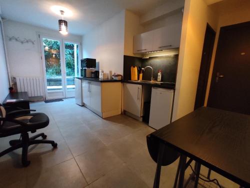 une cuisine avec une table, des chaises et une table ainsi qu'une chambre dans l'établissement Little Italy, à Mérignac