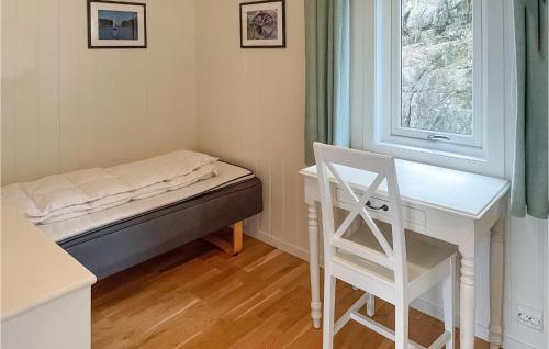 Schlafzimmer mit einem Bett, einem Schreibtisch und einem Fenster in der Unterkunft Cozy Home In Tvedestrand With House Sea View in Tvedestrand