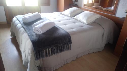 Una gran cama blanca con toallas encima. en Cal Fuste, en Torà de Tost