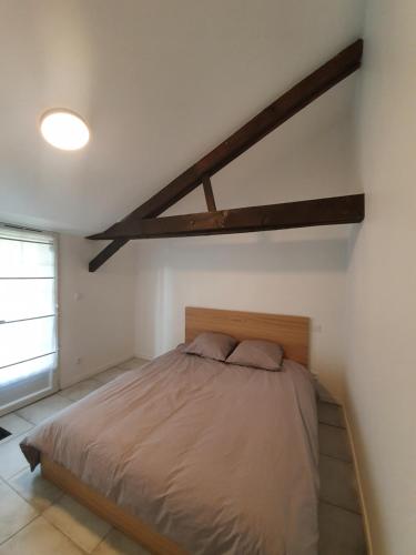 une chambre avec un grand lit dans une pièce dans l'établissement Le Logis, à Coulonges-Ardennes