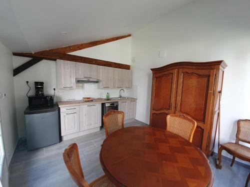 une cuisine avec une table et des chaises dans une pièce dans l'établissement Le Logis, à Coulonges-Ardennes
