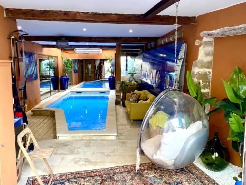a swimming pool in a living room with a swing at Artishow in L'Isle-sur-la-Sorgue