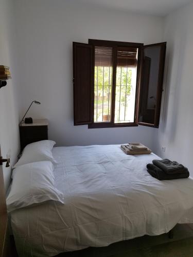 a bedroom with a large white bed with a window at Las Tobas in Puerto-Moral