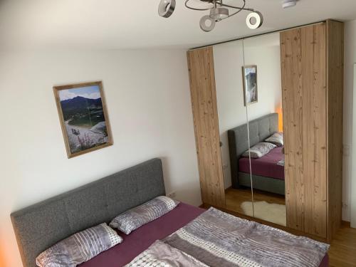 un dormitorio con una cama y un espejo en Apartment Kumitzblick, en Obersdorf