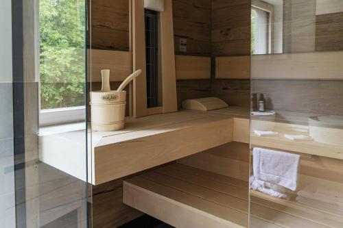 bagno con pareti in legno e box doccia in vetro di Hotel Ottenstein - Das Wohlfühlhotel a Rastenfeld