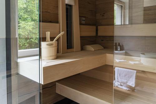 a bathroom with wooden walls and a glass shower stall at Hotel Ottenstein - Das Wohlfühlhotel in Rastenfeld