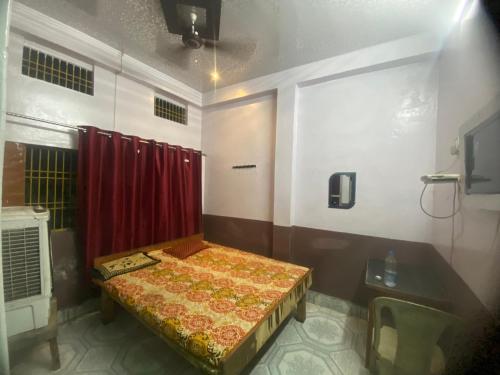 a room with a bed and a red curtain at Hotel Yatri Niwas in Varanasi