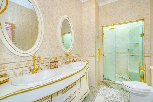 Un baño con dos lavabos y una ducha y un inodoro. en Baku Avangard Apartment, en Baku