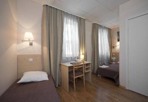 um quarto com uma cama, uma secretária e uma janela em Hotel BEST with FREE PARKING em Riga