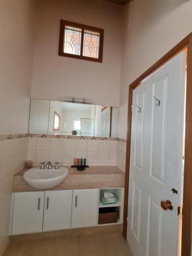 un bagno con lavandino e specchio di Maple Ridge Cottages a Dumbalk
