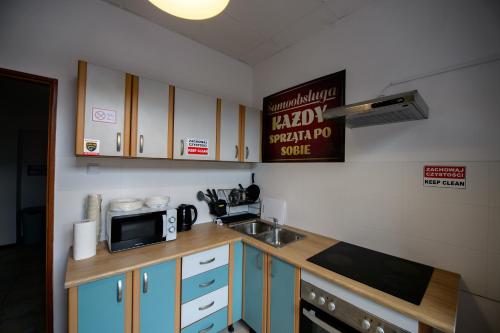 a small kitchen with a microwave and a sink at ONRest Hostel Centrum Żytnia 8 FaktVat in Kielce