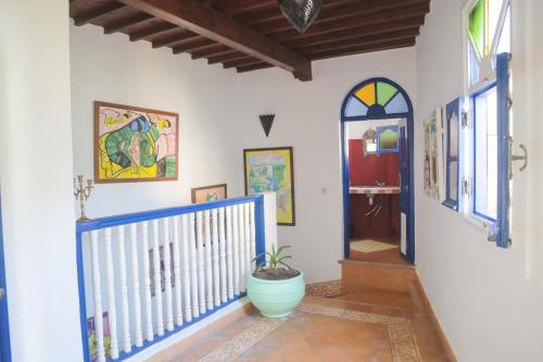 a hallway with a blue door and a potted plant at Riad Dar Afram in Essaouira