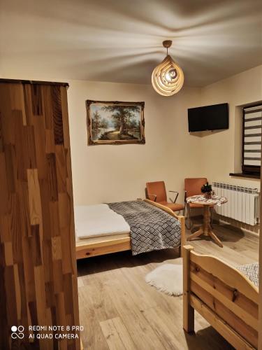 a bedroom with a bed and a table with a chair at Willa Tatry in Bańska Niżna