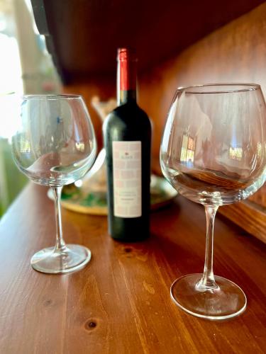 two wine glasses sitting on a table with a bottle of wine at Tra Terra e Mare in Flumini di Quartu