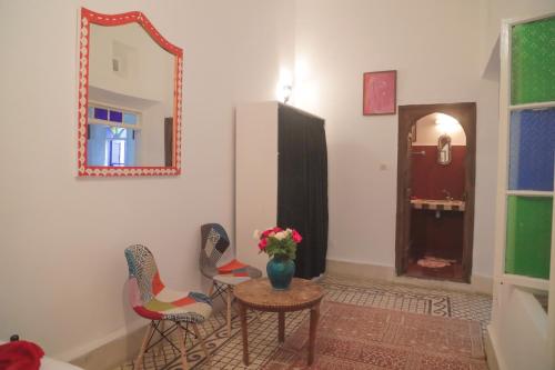 a room with two chairs and a table and a mirror at Riad Dar Afram in Essaouira