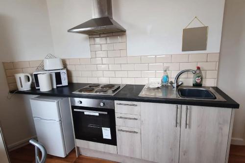a kitchen with a sink and a stove at One bedroom studio apartment close to city centre in Sheffield