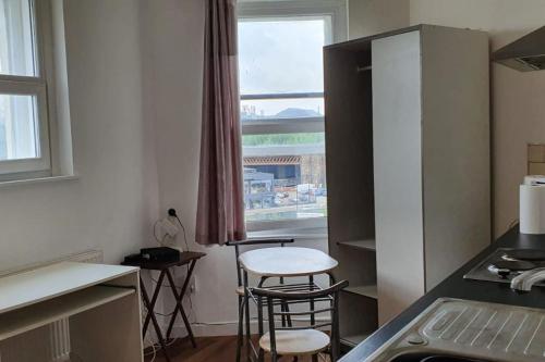a kitchen with two stools and a table and a window at One bedroom studio apartment close to city centre in Sheffield