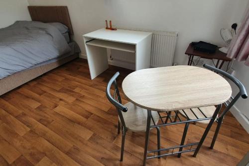 a room with a table and a desk and a bed at One bedroom studio apartment close to city centre in Sheffield