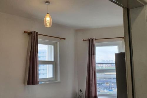 um quarto com duas janelas com cortinas e uma luz em One bedroom studio apartment close to city centre em Sheffield