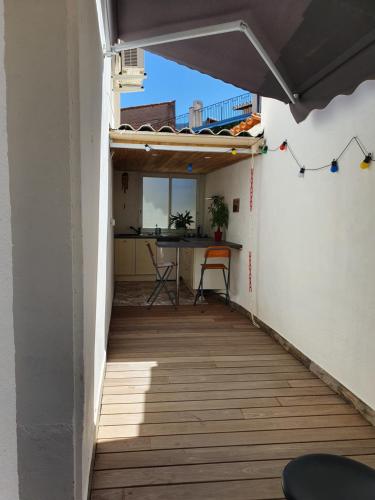 a small balcony with a wooden floor and a table at un air de vacances in Laroque-des-Albères