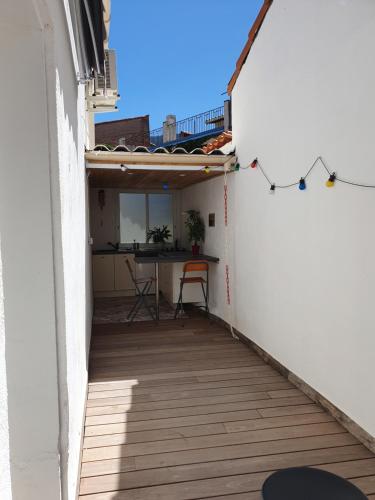a small balcony with a table in a building at un air de vacances in Laroque-des-Albères