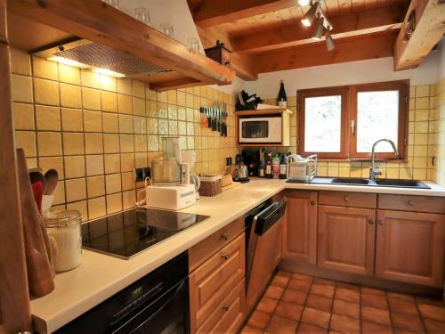 une cuisine avec un évier et une cuisinière four supérieur dans l'établissement Chalet Familial pour 10 Pers. à Proximité des Pistes et Commerces avec Cheminée et Wifi - FR-1-342-232, à Beaufort