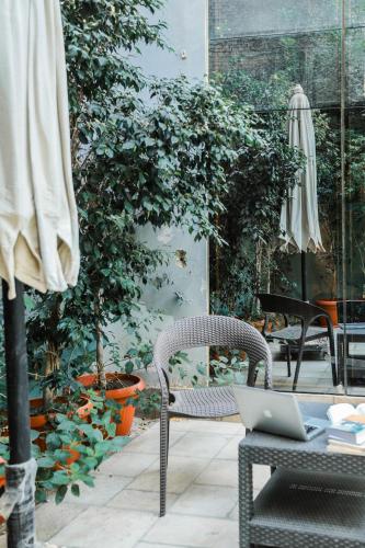 a patio with a chair and a table with a laptop at NewCity Hotel & Suites in Cairo